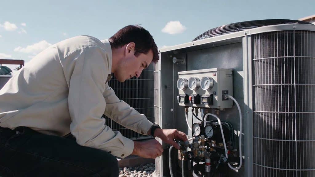An HVAC service technician working on air conditioning unit in Covington GA